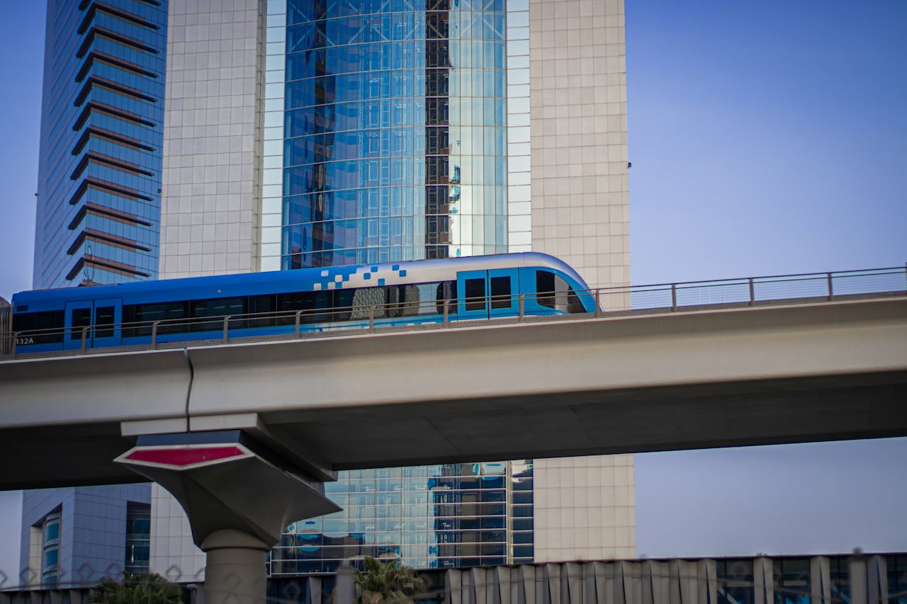 A blue and white train is traveling on a bridge in Dubai