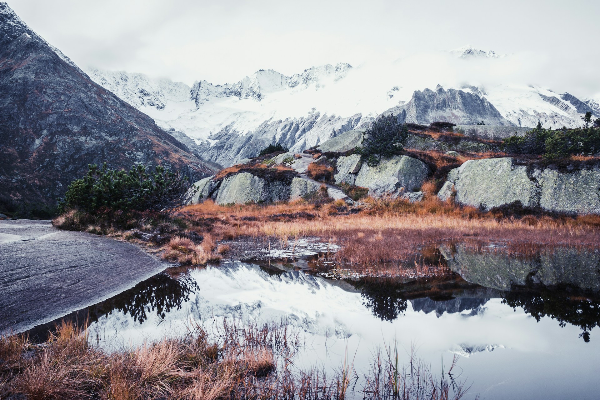 A serene lake with mountains reflecting on the water.