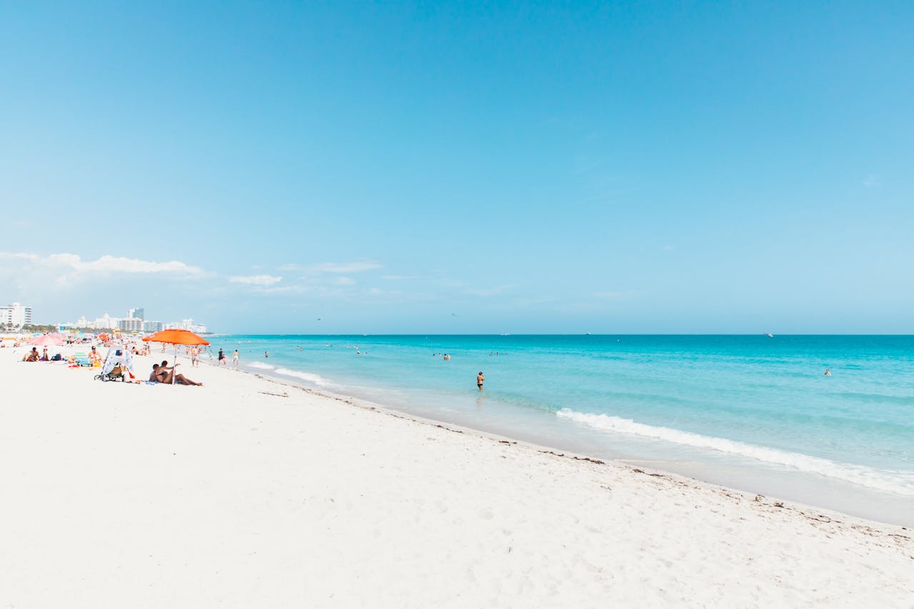 Sunny beach scene with people relaxing under umbrellas on Vacation in Miami