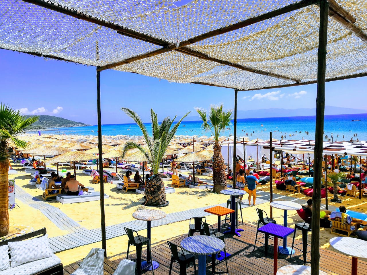 People Sitting under Beach Huts